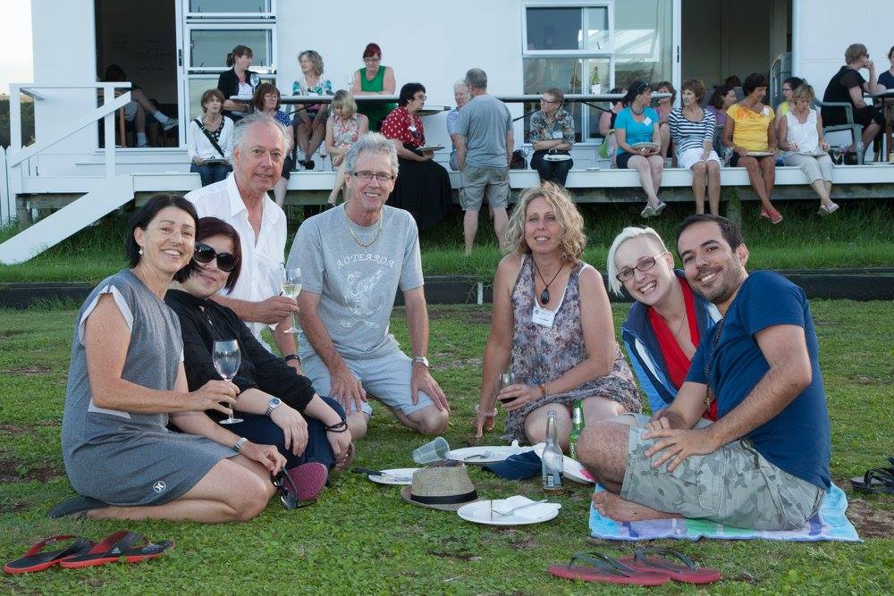Picture of five choir members and Uwe Grodd, relaxing in the grass eating a meal