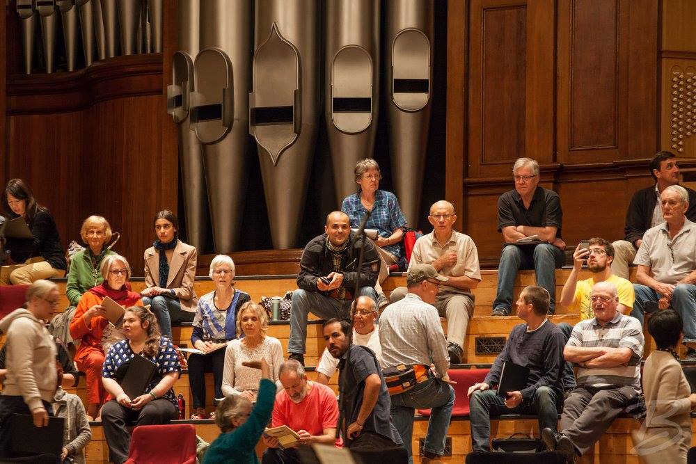 Picture of several choir members in relaxed clothes in during a rehearsal break in the Town Hall