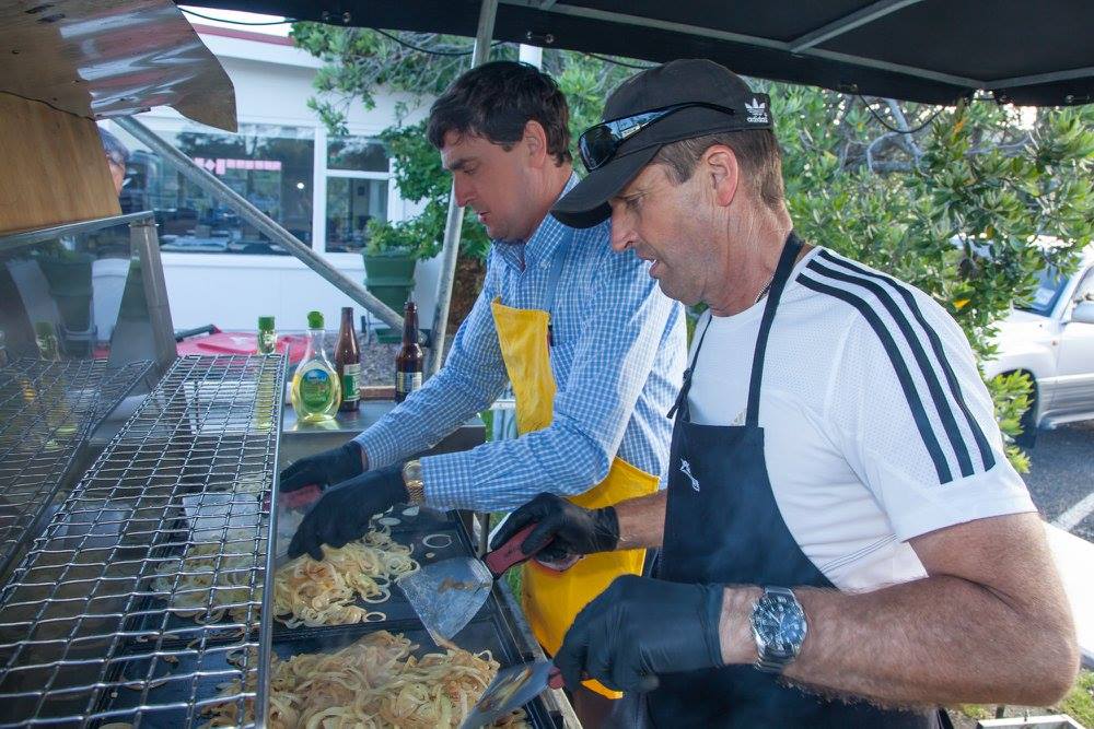 Picture of two choir members cooking a barbeque