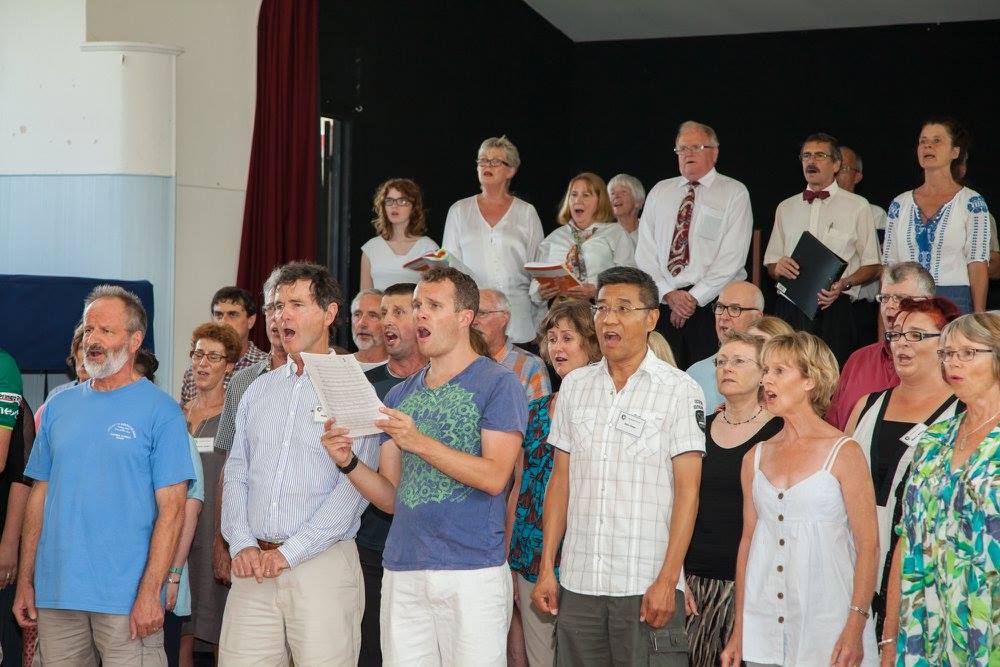 Picture of several choir smiling in an informal concert on Waiheke Island