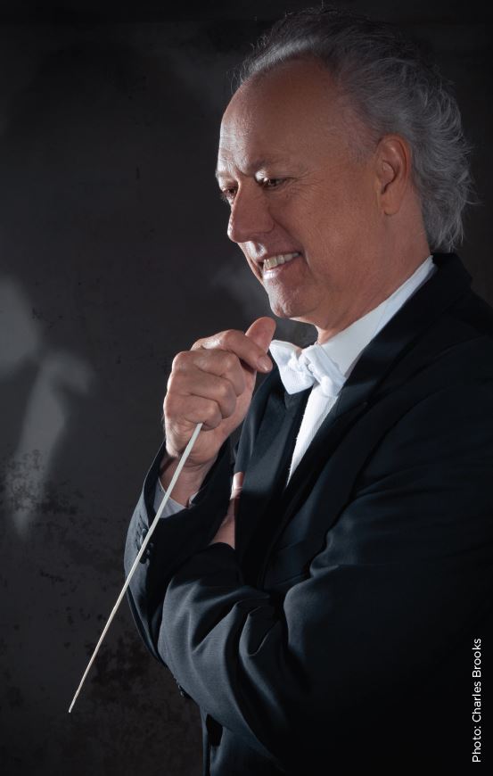 Picture of Uwe Grodd, Auckland Choral Music director, with a conductor's baton
